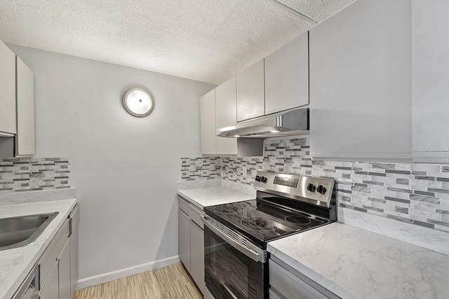 kitchen featuring stainless steel electric range oven, backsplash, a textured ceiling, and under cabinet range hood