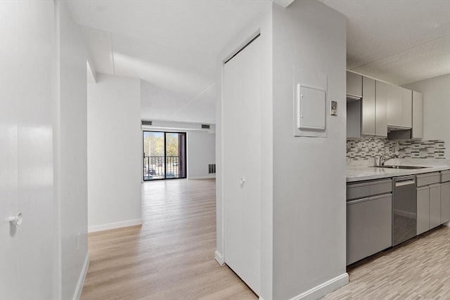 hallway with light wood-style floors, a sink, and baseboards