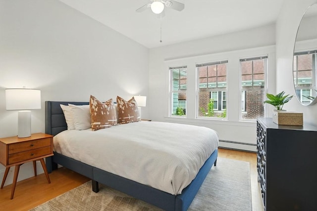 11 Longfellow Rd, Cambridge, MA 02138 - bedroom with a baseboard heating unit, light wood finished floors, multiple windows, and a ceiling fan