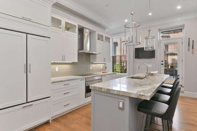 65 Marlborough St Unit 1-6, Boston, MA 02116 - kitchen with wall chimney range hood, oven, ornamental molding, decorative backsplash, and a kitchen breakfast bar