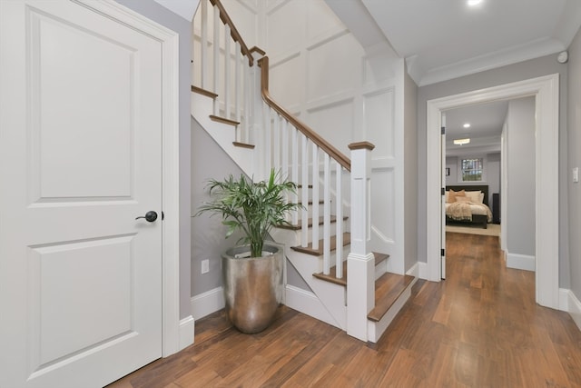 stairway featuring wood-type flooring and ornamental molding