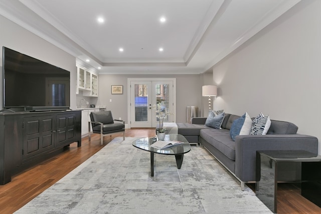 living room with french doors, hardwood / wood-style floors, sink, crown molding, and a raised ceiling