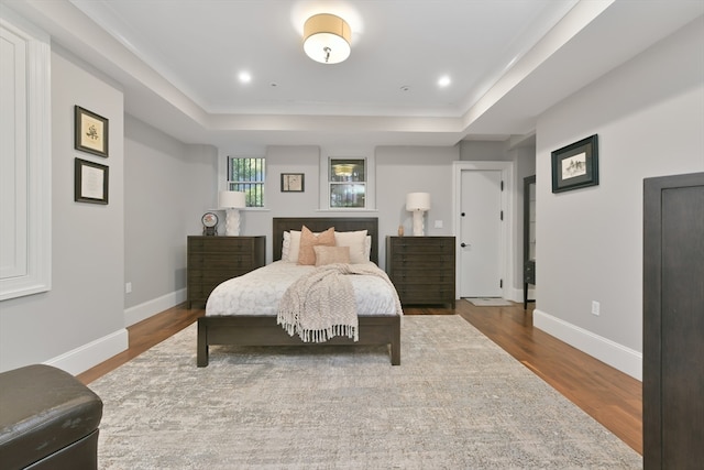 bedroom featuring hardwood / wood-style flooring and a tray ceiling