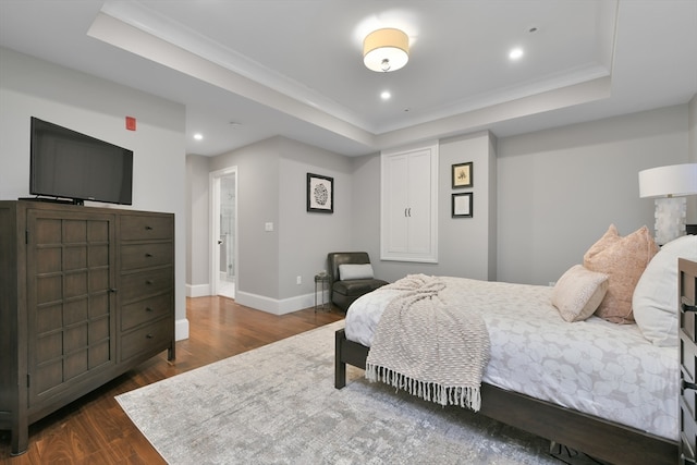 bedroom with dark wood-type flooring and a raised ceiling