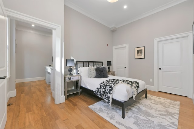 bedroom featuring light wood-type flooring and crown molding