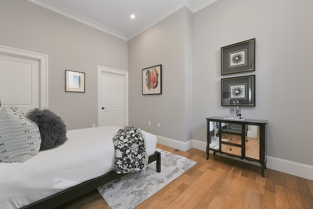 bedroom featuring ornamental molding and light hardwood / wood-style floors