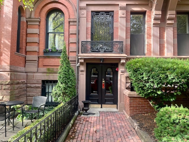 doorway to property with a balcony and french doors