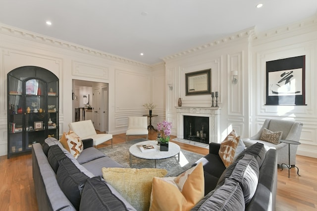 living room with a fireplace, hardwood / wood-style flooring, and crown molding