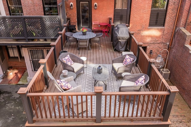 wooden terrace with a grill and an outdoor living space