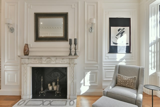 sitting room with a premium fireplace and light hardwood / wood-style flooring