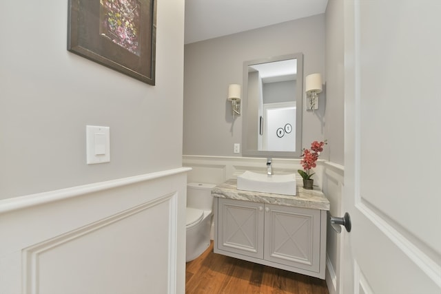 bathroom with hardwood / wood-style flooring, vanity, and toilet