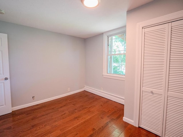 461 Aiken Ave, Dracut, MA 01826 - unfurnished bedroom featuring baseboard heating, wood finished floors, and a closet