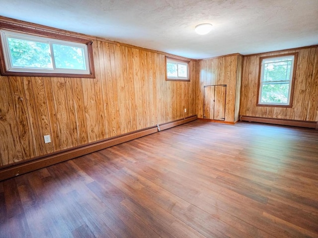 461 Aiken Ave, Dracut, MA 01826 - unfurnished room with baseboard heating, wood finished floors, plenty of natural light, and wood walls
