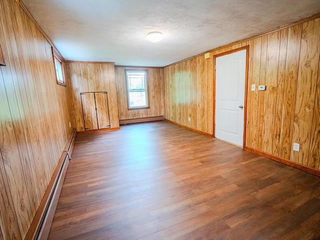 461 Aiken Ave, Dracut, MA 01826 - unfurnished room with wood finished floors, baseboard heating, a baseboard radiator, and wood walls