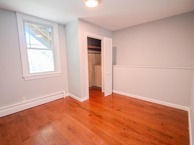 461 Aiken Ave, Dracut, MA 01826 - unfurnished bedroom with a baseboard radiator, wood finished floors, and a closet