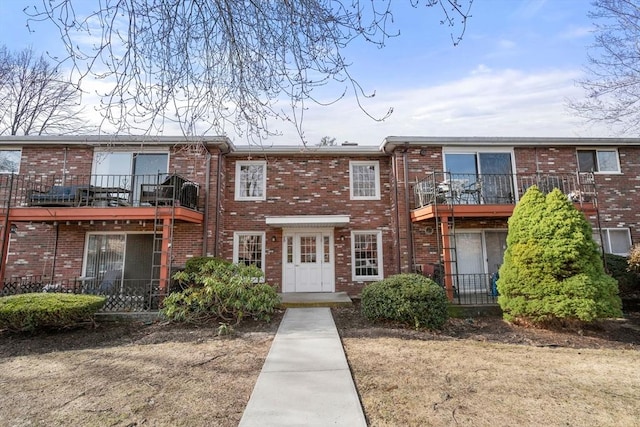 townhome / multi-family property featuring brick siding and a balcony