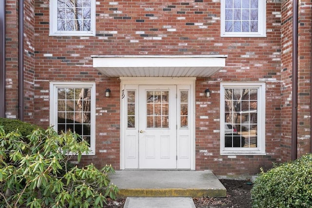 doorway to property featuring brick siding