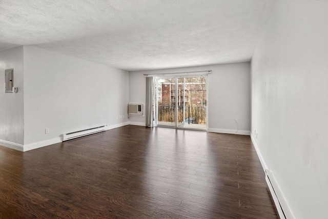 empty room featuring baseboards, a baseboard radiator, dark wood-type flooring, an AC wall unit, and a textured ceiling