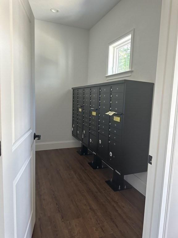 interior space with a mail area and hardwood / wood-style floors