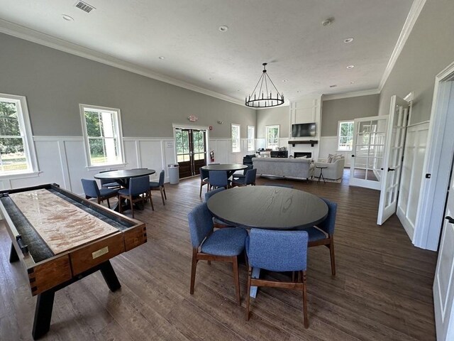 dining room featuring crown molding, dark hardwood / wood-style flooring, and plenty of natural light