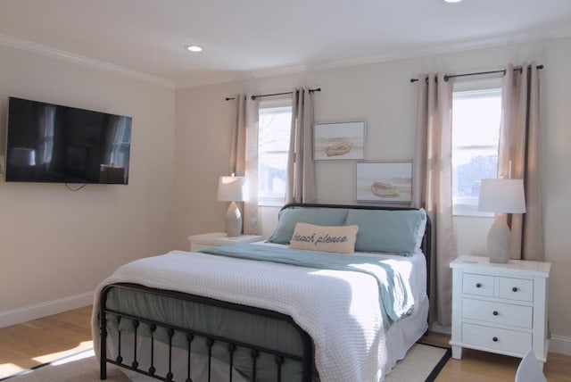 bedroom featuring baseboards, multiple windows, and light wood finished floors