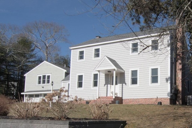 colonial home with roof with shingles, a front lawn, crawl space, and central air condition unit