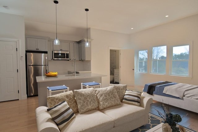 living area featuring light wood-style flooring and recessed lighting