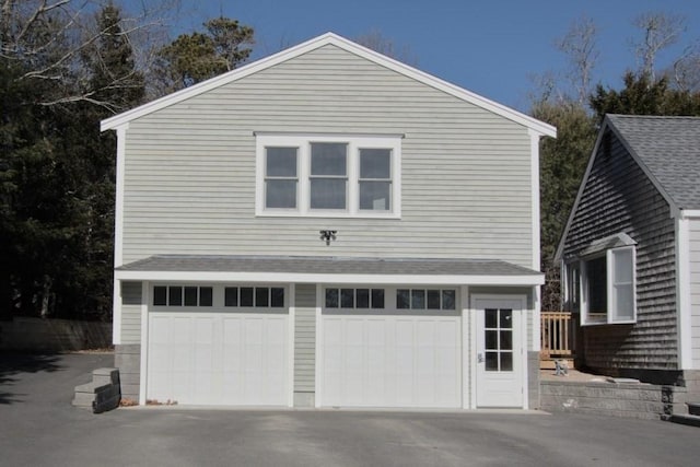 view of side of property with driveway and an attached garage