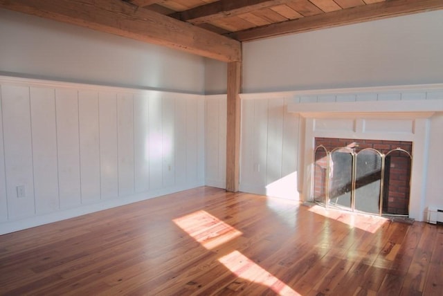 spare room featuring wooden ceiling, a brick fireplace, hardwood / wood-style floors, and beam ceiling