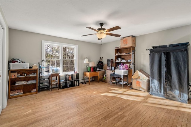 office featuring ceiling fan, light hardwood / wood-style floors, and a baseboard radiator