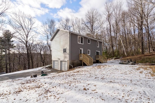 snow covered house featuring a garage