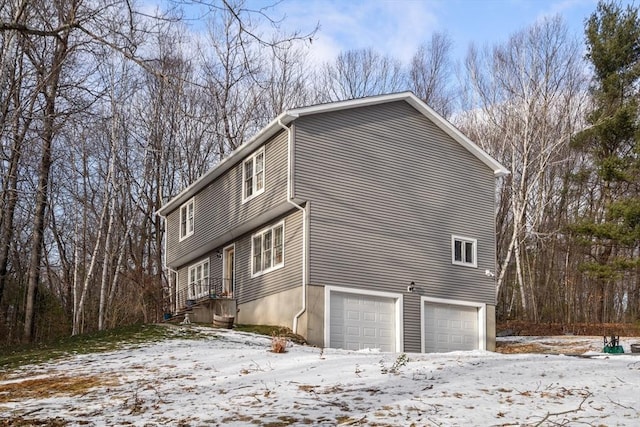 snow covered property with a garage