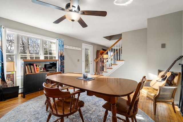 dining area with wood-type flooring and ceiling fan