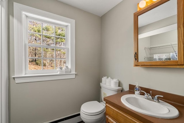 bathroom featuring toilet, vanity, and a baseboard radiator