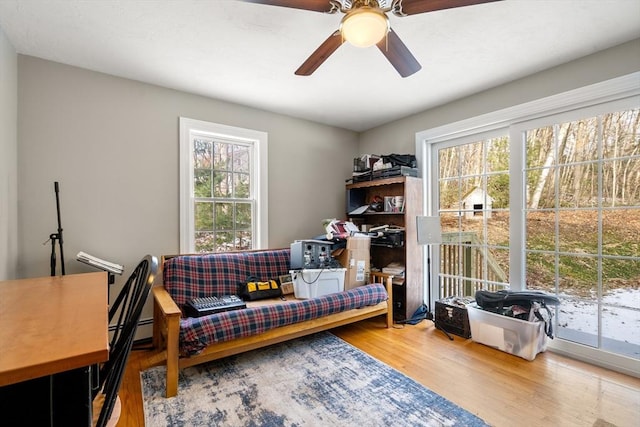 sitting room with a healthy amount of sunlight, ceiling fan, and hardwood / wood-style flooring