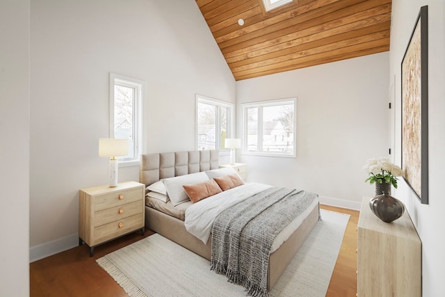 bedroom with multiple windows, wood ceiling, hardwood / wood-style floors, and a skylight