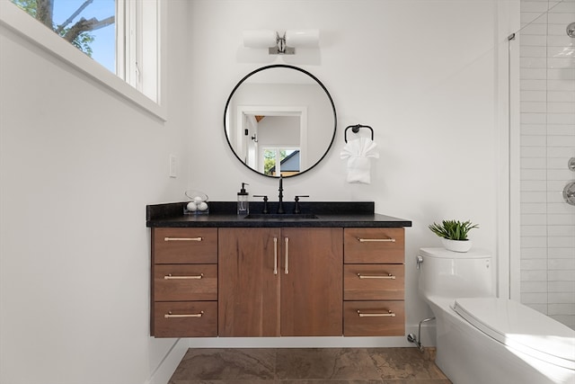 bathroom featuring vanity, toilet, and a tile shower