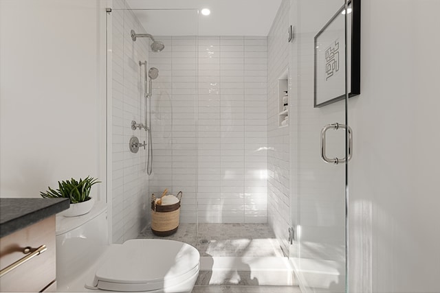 bathroom featuring an enclosed shower, toilet, and vanity