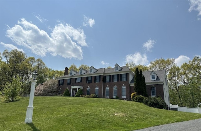 6 Everett Cir, Hopkinton, MA 01748 - view of front facade featuring brick siding, a front lawn, fence, and a chimney
