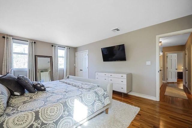 bedroom featuring visible vents, wood finished floors, and baseboards