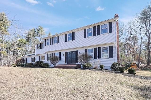 colonial house with a front lawn and a chimney