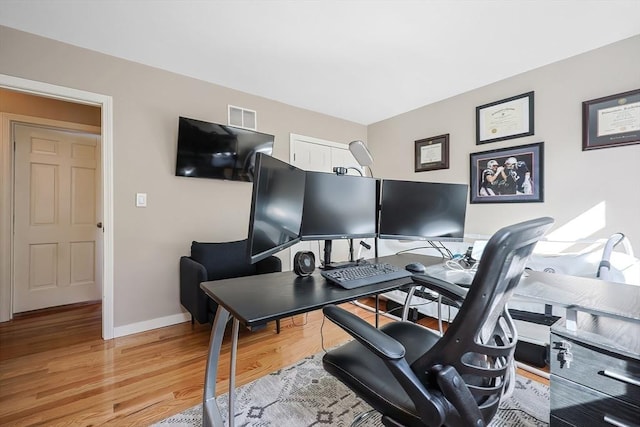 office featuring visible vents, light wood-style floors, and baseboards