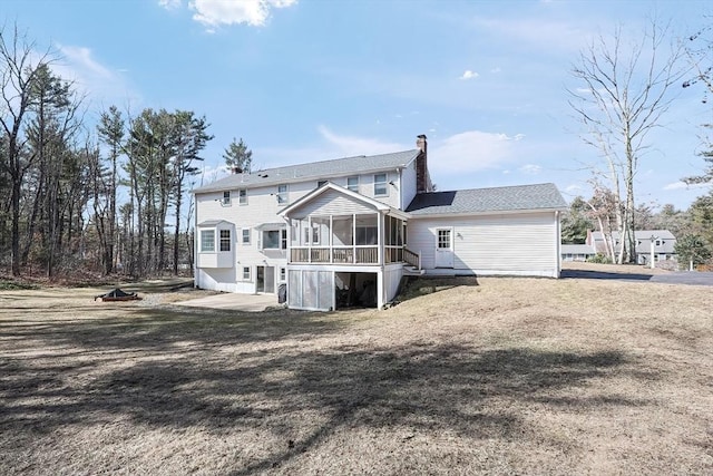 back of property featuring a chimney and a sunroom