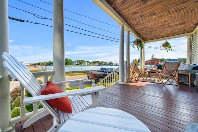 wooden deck featuring a water view and covered porch