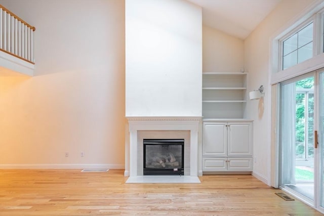 43 Blossom Sq Unit 43, Holden, MA 01520 - unfurnished living room with wood finished floors, a fireplace with flush hearth, and high vaulted ceiling