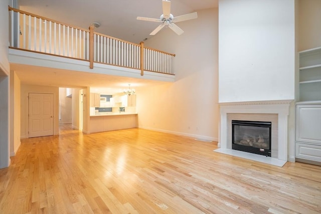 43 Blossom Sq Unit 43, Holden, MA 01520 - unfurnished living room with high vaulted ceiling, wood finished floors, a fireplace with flush hearth, a chandelier, and a ceiling fan