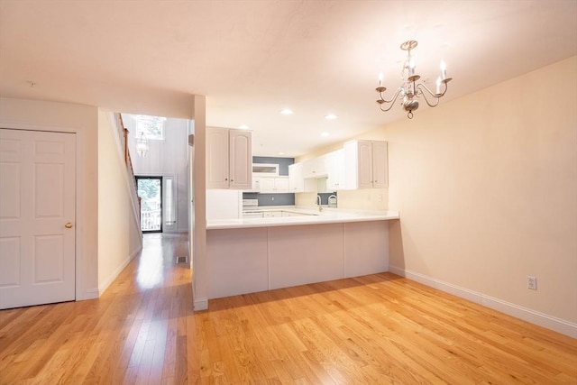 43 Blossom Sq Unit 43, Holden, MA 01520 - kitchen featuring a chandelier, light wood-style flooring, a peninsula, light countertops, and recessed lighting