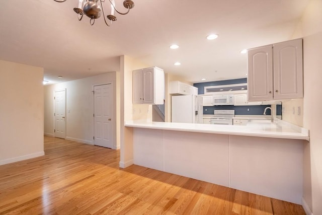43 Blossom Sq Unit 43, Holden, MA 01520 - kitchen featuring white appliances, a chandelier, light wood finished floors, a peninsula, and recessed lighting