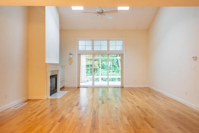 43 Blossom Sq Unit 43, Holden, MA 01520 - unfurnished living room featuring a ceiling fan, light wood-style floors, a fireplace with flush hearth, and lofted ceiling