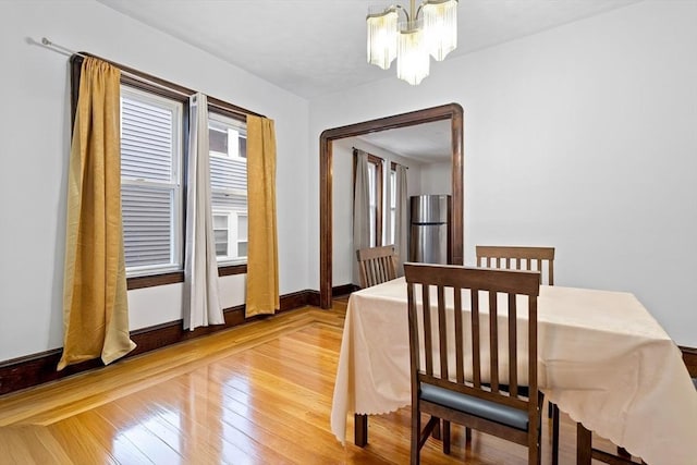 570 William St, Fall River, MA 02721 - dining space featuring a chandelier, light wood-style floors, and baseboards